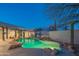 Backyard pool and outdoor kitchen with rock waterfall and xeriscaped desert landscaping at 30600 N Pima Rd # 19, Scottsdale, AZ 85266