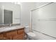 Bathroom with wood cabinets, granite counters, large mirror, and a shower-tub with sliding glass doors at 3650 W Denali Dr, Anthem, AZ 85086