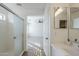 Bright bathroom with tiled floors, white vanity, walk-in shower and a peek into the bedroom at 39237 N Acadia Way, Anthem, AZ 85086