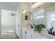 Bright bathroom boasts double vanity, matte black faucets, tiled floor and a peek into the bedroom at 39237 N Acadia Way, Anthem, AZ 85086