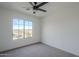 Well-lit bedroom with a ceiling fan and a window providing natural light and landscape views at 39237 N Acadia Way, Anthem, AZ 85086