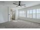 Sunlit bedroom with plush carpet, multiple windows and a view of the en-suite bath with glass enclosed shower at 39237 N Acadia Way, Anthem, AZ 85086