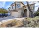 Home's front exterior features desert landscaping, a two-car garage, and a covered entryway at 39237 N Acadia Way, Anthem, AZ 85086