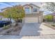 Front exterior of home features a well-manicured yard, a two-car garage, and a paved driveway at 39237 N Acadia Way, Anthem, AZ 85086