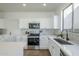 Well-lit kitchen features white cabinets, subway tile backsplash, stainless steel appliances, and tile flooring at 39237 N Acadia Way, Anthem, AZ 85086