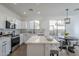 The bright kitchen features stainless steel appliances and a large kitchen island with seating at 39237 N Acadia Way, Anthem, AZ 85086