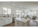 This bright kitchen features stainless steel appliances, quartz countertops and an island with seating at 39237 N Acadia Way, Anthem, AZ 85086