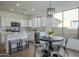 Bright kitchen nook with table and chairs adjacent to the updated kitchen with stainless steel appliances at 39237 N Acadia Way, Anthem, AZ 85086