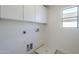 Bright laundry room featuring white cabinets, tile floor and utility connections at 39237 N Acadia Way, Anthem, AZ 85086