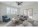 Bright living room features neutral paint, ceiling fan, large window, and sliding doors leading to the patio at 39237 N Acadia Way, Anthem, AZ 85086