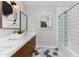 Bright bathroom with a double vanity, white tile, and glass-enclosed tub at 3931 E Glenrosa Ave, Phoenix, AZ 85018