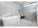 Modern bathroom featuring a soaking tub, glass shower, and herringbone tile flooring at 3931 E Glenrosa Ave, Phoenix, AZ 85018