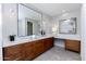 Bathroom with double sinks, wood cabinets, marble countertop, and herringbone tile floors at 3931 E Glenrosa Ave, Phoenix, AZ 85018