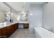 Bright bathroom with double vanity, soaking tub, tiled walls, and glass shower enclosure at 3931 E Glenrosa Ave, Phoenix, AZ 85018