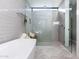 Modern bathroom featuring a soaking tub, glass shower, and herringbone tile flooring at 3931 E Glenrosa Ave, Phoenix, AZ 85018