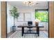 Inviting home office featuring a desk, modern light fixture, potted tree, and serene backyard views at 3931 E Glenrosa Ave, Phoenix, AZ 85018