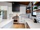 Kitchen features a stainless steel Wolf range, subway tile backsplash, and open wood shelving at 3931 E Glenrosa Ave, Phoenix, AZ 85018