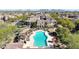 Aerial view of a resort-style pool, lush landscaping, and residential buildings in a vibrant community at 3935 E Rough Rider Rd # 1055, Phoenix, AZ 85050