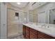 Bathroom featuring a glass-enclosed shower and double sink vanity with wood cabinets at 3935 E Rough Rider Rd # 1055, Phoenix, AZ 85050