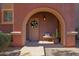 Inviting arched entrance with a decorated front door, bench, and potted plants at 3935 E Rough Rider Rd # 1055, Phoenix, AZ 85050