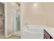 Bathroom featuring soaking tub, shower with glass door, and neutral colored walls at 41375 W Barcelona Dr, Maricopa, AZ 85138