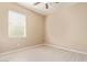 An empty bedroom with a ceiling fan, window with blinds, and wood-look floors at 41375 W Barcelona Dr, Maricopa, AZ 85138