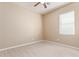 An empty bedroom with a ceiling fan, window with blinds, and wood-look floors at 41375 W Barcelona Dr, Maricopa, AZ 85138