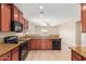 Open kitchen featuring granite countertops, dark wood cabinets and stainless steel dishwasher at 41375 W Barcelona Dr, Maricopa, AZ 85138