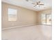 Spacious living room with wood-look floors, ceiling fan, and sliding glass doors to the backyard at 41375 W Barcelona Dr, Maricopa, AZ 85138