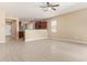 Open-concept living space with wood-look floors, a ceiling fan, and kitchen with granite countertops at 41375 W Barcelona Dr, Maricopa, AZ 85138