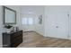 Home entryway featuring wood-look flooring, a black dresser, white doors, and a decorative mirror at 4501 E Osage Ct, Phoenix, AZ 85044