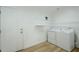 Bright laundry room with white washer, dryer, shelving and wood-look floors at 4501 E Osage Ct, Phoenix, AZ 85044