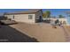 Large, gravel backyard with covered patio, pool, and exterior home view at 4541 N 129Th Dr, Litchfield Park, AZ 85340