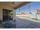 Covered outdoor patio offering a serene view of the backyard pool and lush desert landscape at 4541 N 129Th Dr, Litchfield Park, AZ 85340