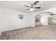 Spacious carpeted primary bedroom with arched doorway, ceiling fan and natural light at 4550 W Bloomfield Rd, Glendale, AZ 85304