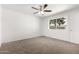 Bright bedroom featuring plush carpeting, a ceiling fan, and a large window at 4550 W Bloomfield Rd, Glendale, AZ 85304