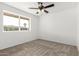 Bright bedroom features neutral carpet, a ceiling fan, and a sun-filled window at 4550 W Bloomfield Rd, Glendale, AZ 85304