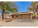 Charming single-story home featuring a wide driveway, a two car garage, and solar panels at 4550 W Bloomfield Rd, Glendale, AZ 85304