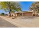 Single-story home with a spacious driveway and desert landscaping, and solar panels at 4550 W Bloomfield Rd, Glendale, AZ 85304