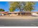 Charming brick home with a mature tree, desert landscaping, and solar panels at 4550 W Bloomfield Rd, Glendale, AZ 85304