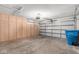 Well-lit garage with built-in wood cabinets and ample storage space at 4550 W Bloomfield Rd, Glendale, AZ 85304