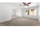 Bright living room with plush carpet, ceiling fan, large window and arched entryway at 4550 W Bloomfield Rd, Glendale, AZ 85304