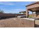 A view of the patio with an outdoor kitchen, pergola and low maintenance landscaping at 4658 S Rufino Ln, Gold Canyon, AZ 85118