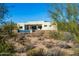 An exterior view showcasing the modern home with desert landscaping at 5468 E Dove Valley Rd, Cave Creek, AZ 85331