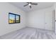 Bright bedroom featuring neutral carpet, a ceiling fan, and an outdoor view at 5468 E Dove Valley Rd, Cave Creek, AZ 85331