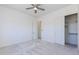 Bright bedroom featuring neutral carpet, a ceiling fan, and closet space at 5468 E Dove Valley Rd, Cave Creek, AZ 85331