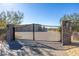 Long paved driveway leads up to the private gated entry with stone pillars at 5468 E Dove Valley Rd, Cave Creek, AZ 85331