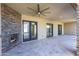 Covered patio featuring stone fireplace, ceiling fan, and multiple doorways for indoor/outdoor living at 5468 E Dove Valley Rd, Cave Creek, AZ 85331