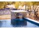 Close up of pool waterfall with attractive stone siding, blue tiles, and desert landscaping at 5468 E Dove Valley Rd, Cave Creek, AZ 85331