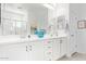 Bright bathroom featuring double sinks with white cabinetry, a large mirror, and a separate shower at 5624 S Winchester --, Mesa, AZ 85212